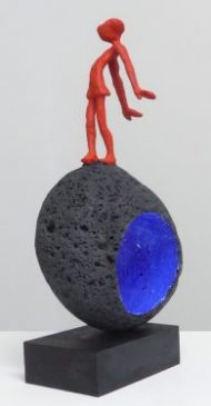 Acróbatas VI. 2016. figura de plomo pintada de azul, sobre escultura en piedra volcánica de Manuel Cyphelly. Figura 13 cm
